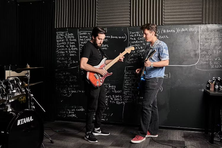 Guitar Player receiving a lesson. 